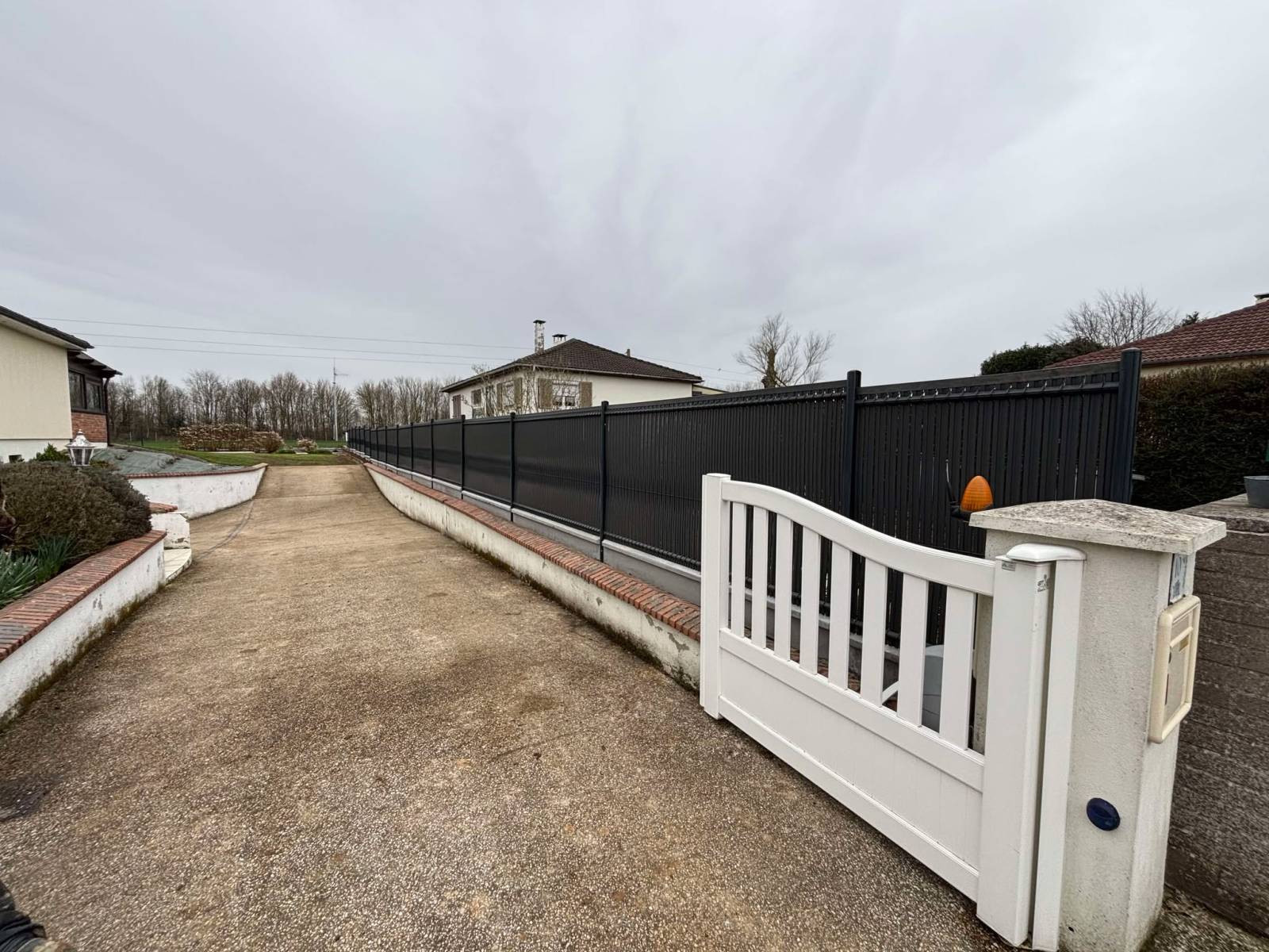 Réalisation d'une clôture en panneaux rigides avec dalles de soubassement et occultants à Saint Ouen de Thouberville