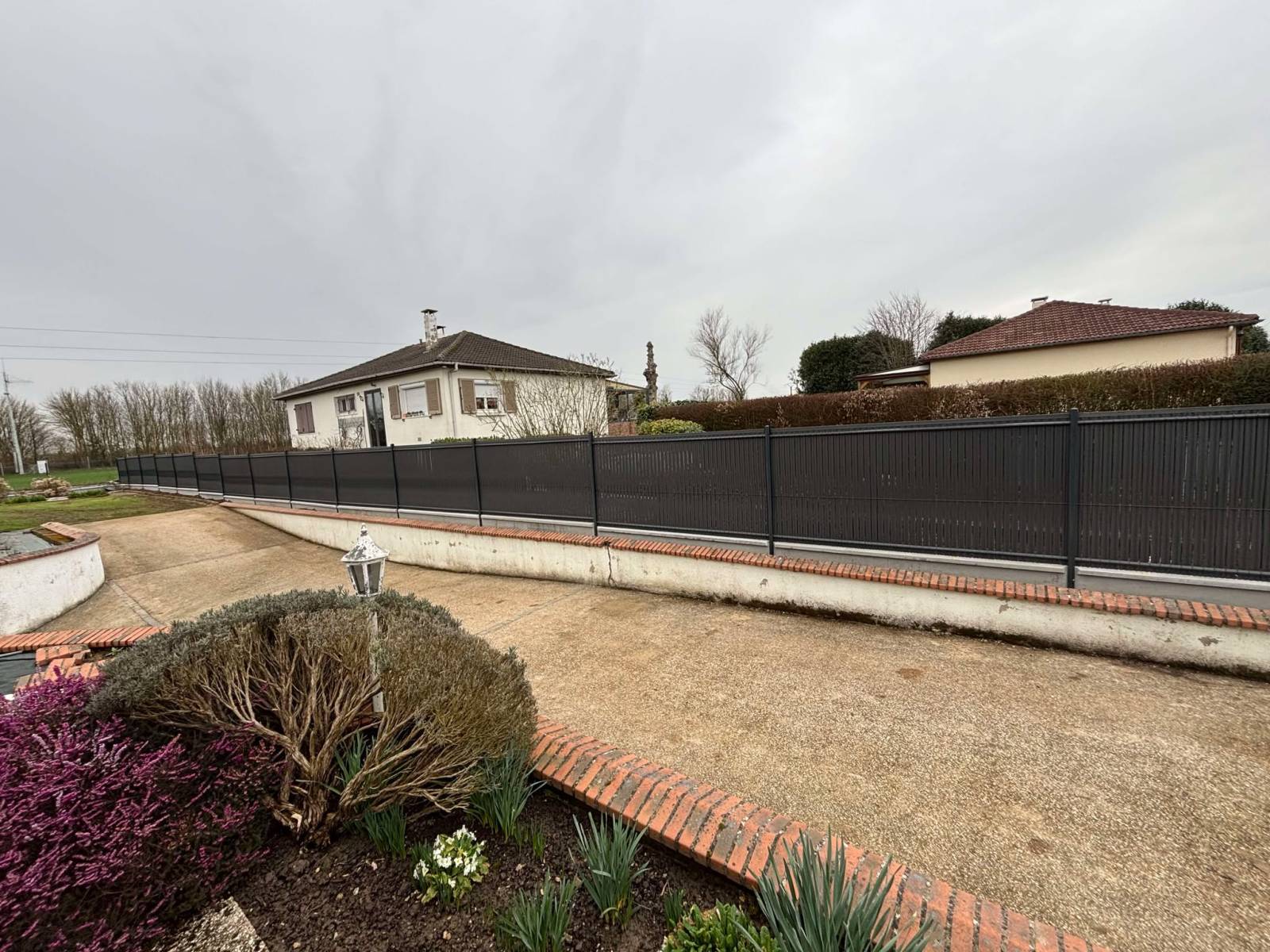 Réalisation d'une clôture en panneaux rigides avec dalles de soubassement et occultants à Saint Ouen de Thouberville