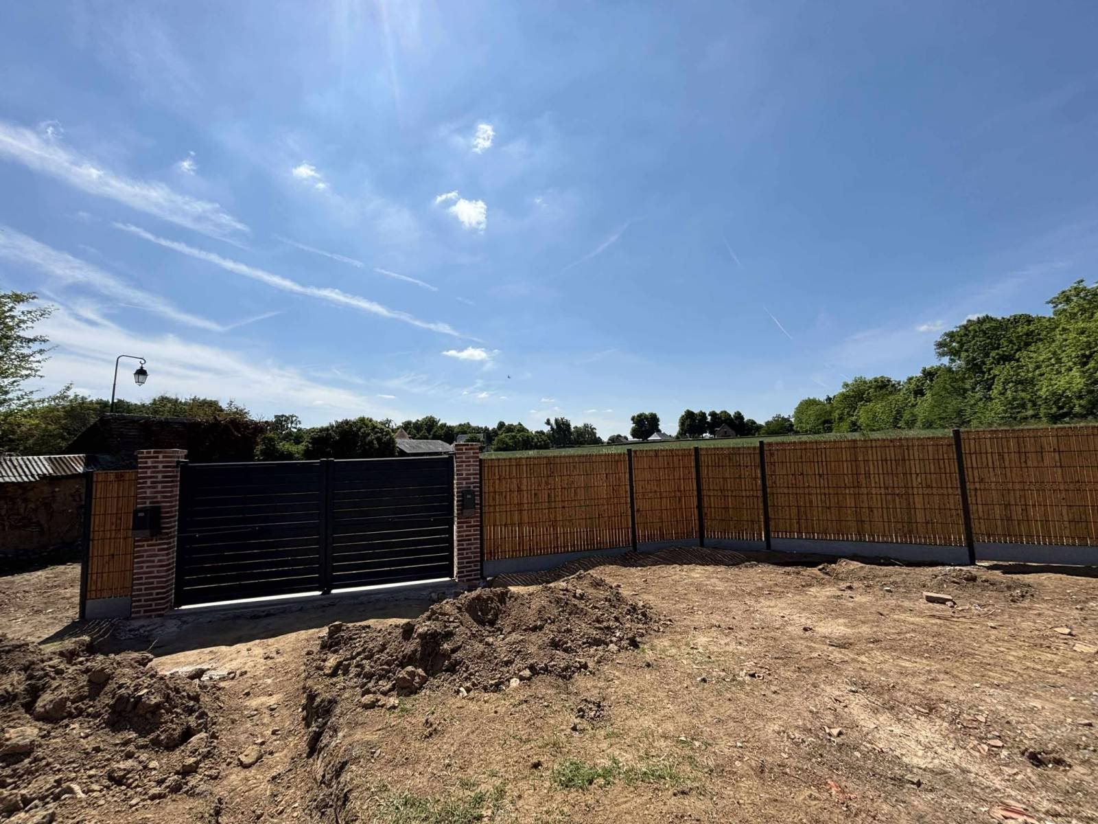 Création de piliers briques, installation d'un portail battant motorisé près du Neubourg
